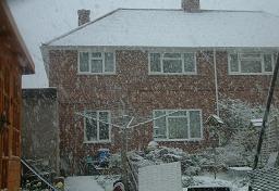 Click for larger image (1,500×1,024) Our brick-built house barely visible from bottom of our garden through heavy snowfall.