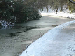 Click for larger image Icy canal curving through cutting.