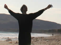 Silhouette of my flying the kite, arms outstretched.