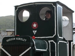 Fiona smiling through a round front window of the little minin train.