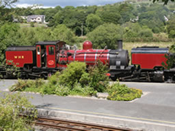 Long red Welsh Highland Railway engine with tenders fore and aft.