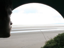 Arched entrance to the tiny lighthouse frames the other implausibly large beach.