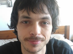 Grinning in a bright room with a bristly excuse for a moustache!