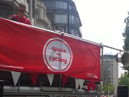 Fabric banner on a vehicle with a platform roof reads: “space for cycling”